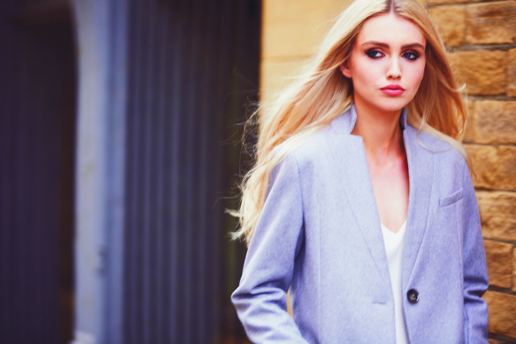 A model wears a grey tailored jacket from AVIE