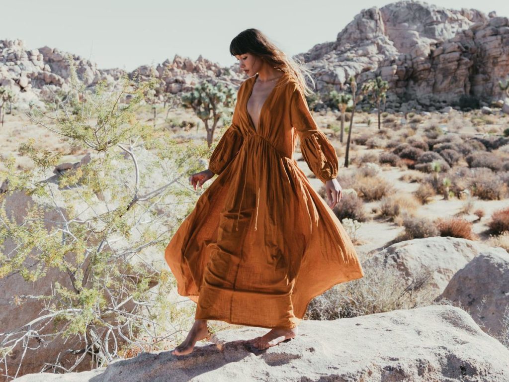 Model wears long sleeved ochre dress.