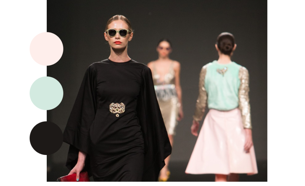 Image from a runway fashion show with circles where shades of black, pink and green are displayed on the left hand side.