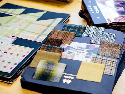 A collection of fabric samples stuck to pieces of blue card