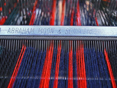 Red and blue Yarn in a loom engraved with Abraham Moon & Son Ltd