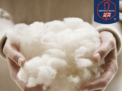 A ball of white wool being held in the hands of an unseen person