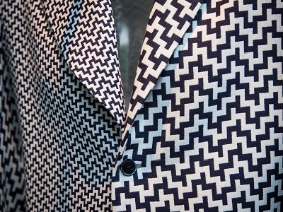 Lapel of a tailored jacket in navy and ecru patterned fabric