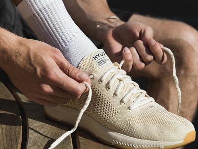 A cream Hylo running shoe being laced up