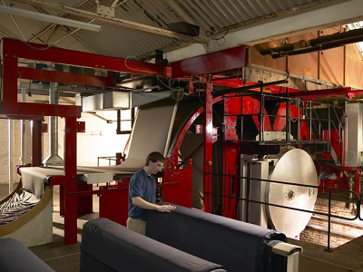 A member of staff checks a roll of blue fabric inside the WT Johnson manufacturing facility